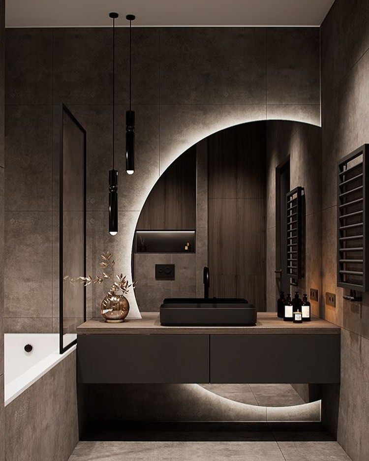 Banheiro cinza-escuro com espelho redondo e luz led atrás