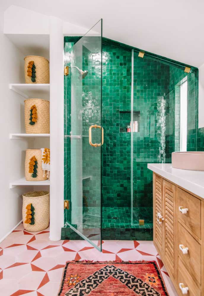 Banheiro com detalhes em madeira, paredes brancas e, na parte do chuveiro, azulejos verdes